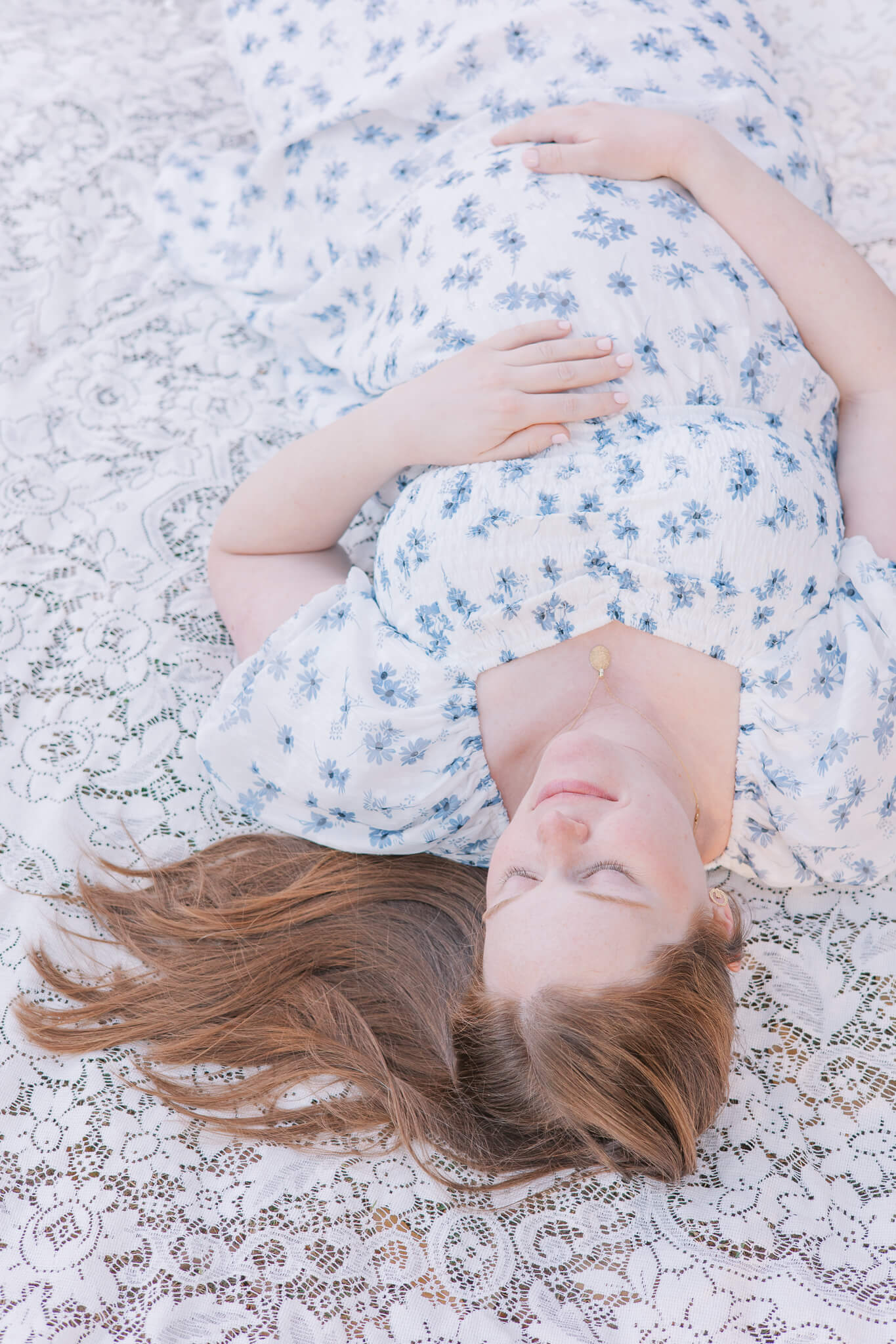 Augusta GA Maternity Photography - Woman lays on blanket holding her baby bump