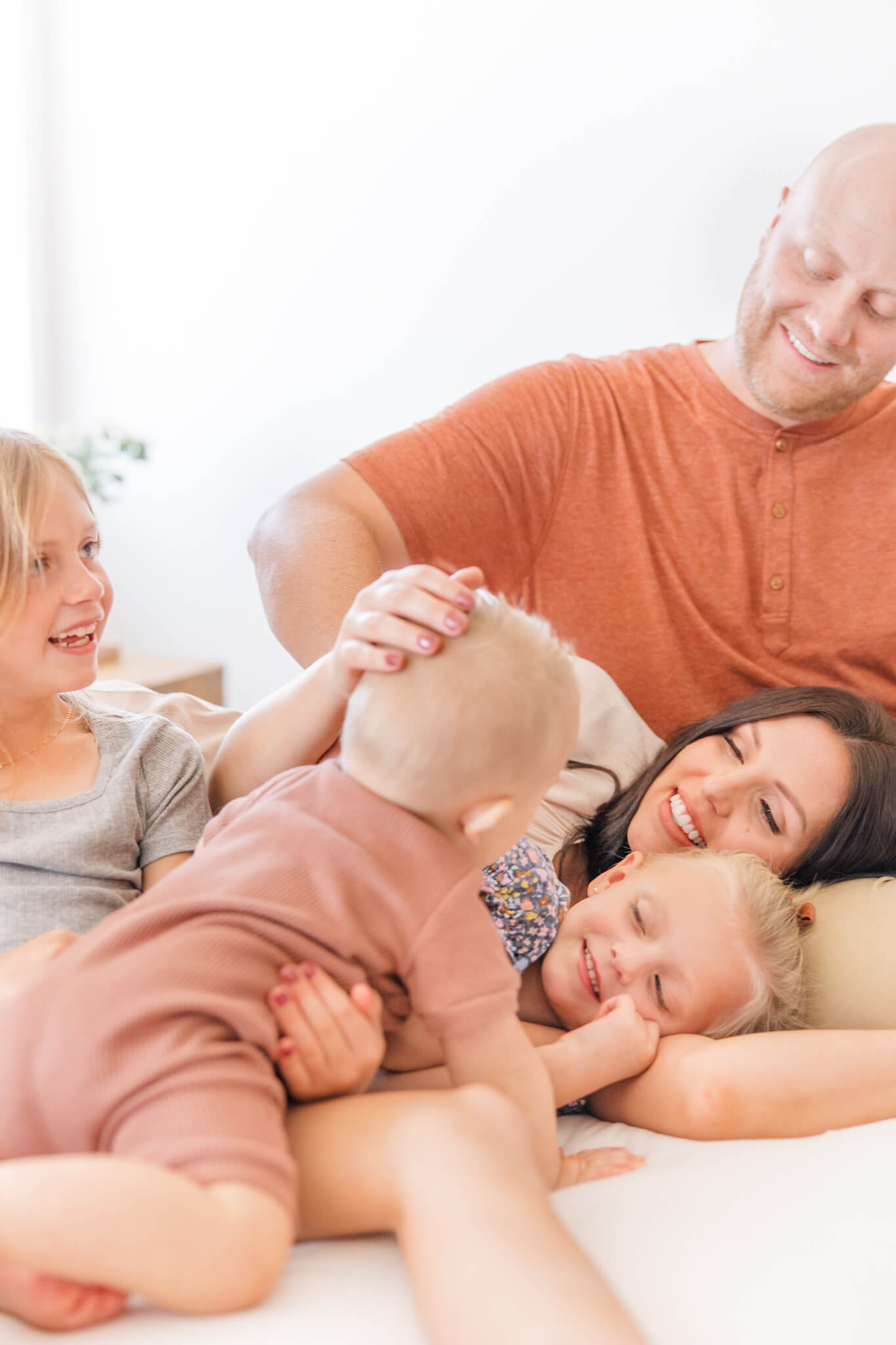 Martinez GA Family Photographer - Family smiles and snuggles on bed together.