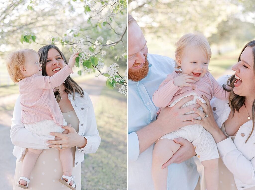 North Augusta SC Photographer - Image of a mother holding a daughter up to touch some tree blooms, and a mother and father smiling at their daughter.