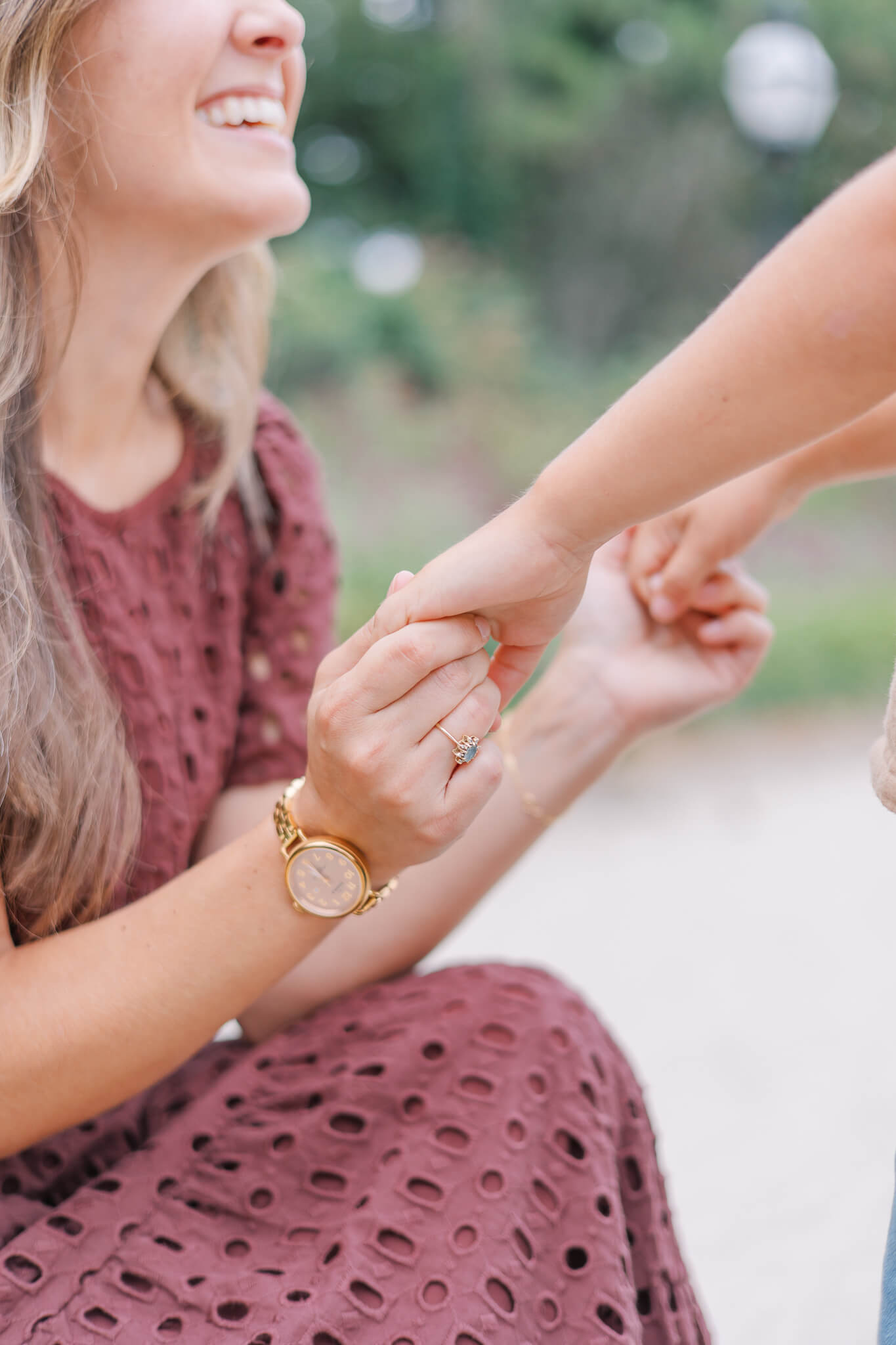 North Augusta Photographer - Mother smiles as she holds onto her child's hands.